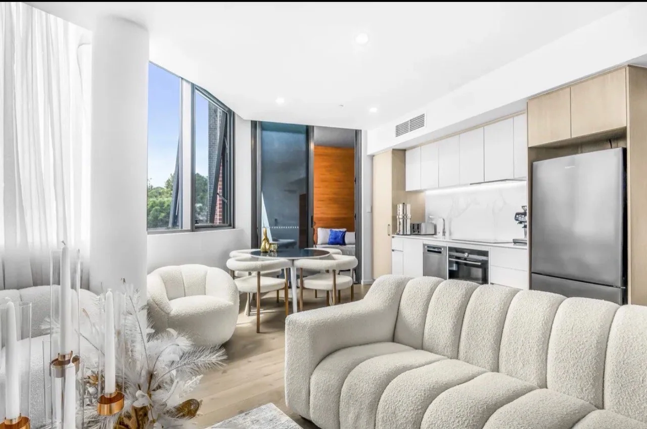 Bright open-plan living and kitchen area with crisp white walls and ceiling